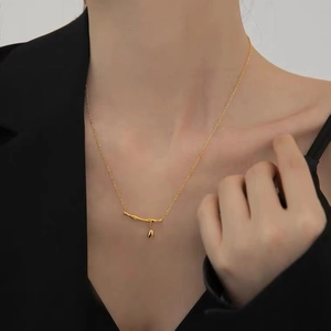 Detailed close-up of 18k gold-plated bamboo joint necklace with a leaf pendant on a model