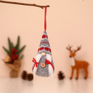 Macro detail of knitted Christmas gnome ornaments hanging on a rustic branch