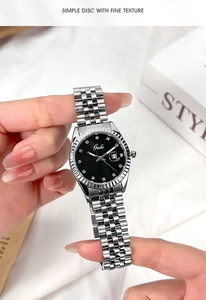 Dettaglio orologio in acciaio argento con quadrante nero e indici in cristallo