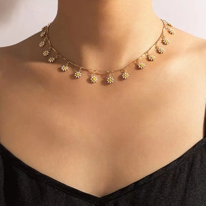 Bohemian gold chain necklace with white daisy enamel flower pendants on model