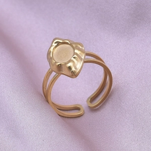 Macro shot of gold stainless steel ring with matte texture on purple silk fabric