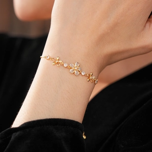 Vue détaillée du bracelet doré ajustable orné de fleurs en zircon et pierres précieuses