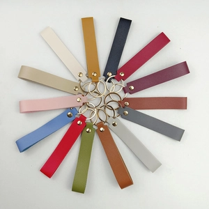 Macro shot of colorful leather keychains with lychee texture and golden metal rivets