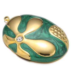Detail of gold oval pendant with green enamel finish and sparkling crystal inlay