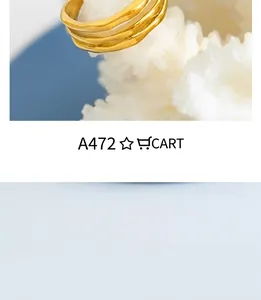 Macro shot of gold wavy textured ring with liquid metal design on white coral stone