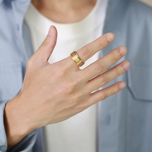Gold stainless steel rotating cross ring with engraved scripture on a male hand