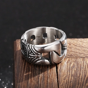Detailed macro view of vintage silver steel ring with tribal patterns on dark wood