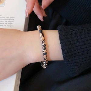 Detail shot of vintage leopard print twisted fabric bracelet on a female wrist