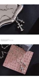 Macro detail of silver double cross pendant with pavé diamonds on a twisted rope chain