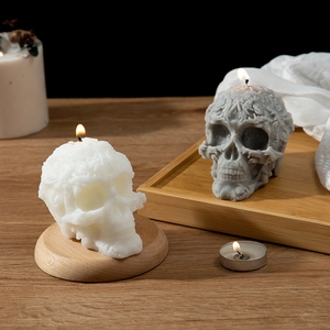Patterned skull scented candles in white and grey wax with detailed floral relief