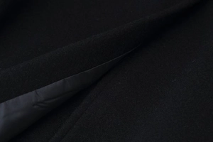Vue détaillée de la texture du tissu en laine noire et de la doublure intérieure lisse