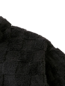 Gros plan détaillé du tissu polaire noir avec un motif texturé à damier géométrique