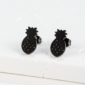 Detailed close-up of pineapple stud earrings in matte black finish on a white stone base