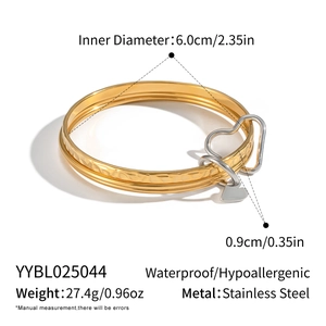 Detail view of 18K gold plated multi-layer stainless steel bracelet with silver heart charm