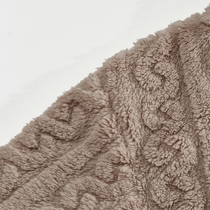 Macro shot showing the thick texture and soft touch of light brown plush fleece fabric