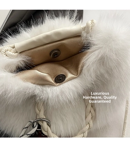 Detail of white plush handbag featuring a metal magnetic clasp and champagne faux leather lining