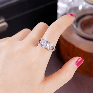 Détail macro de bague argentée avec zircon rond et anneau ajouré en forme de cœur