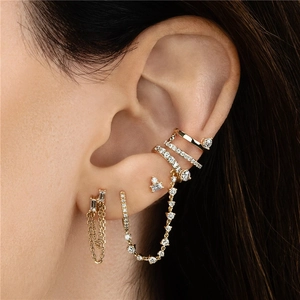 Close-up of gold S925 silver chain earrings and zircon ear cuffs worn by a model