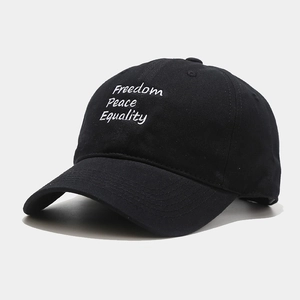 Close-up of Freedom Peace Equality embroidery on a black cotton baseball cap