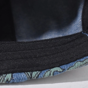 Macro shot of the denim baseball cap showing premium stitching and black inner sweatband
