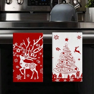 Detail of Christmas microfiber kitchen towels with deer and tree patterns on oven handle