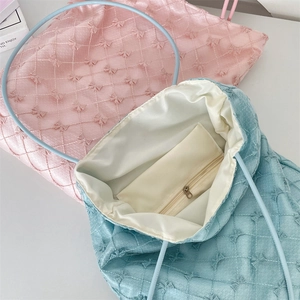 Detail of quilted tote bag interior featuring white lining and a secure zipper pocket