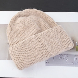 Vista detallada de la textura suave y esponjosa y el punto de canalé de este gorro beige