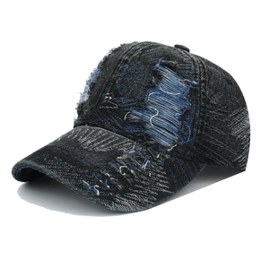 Detailed view of the distressed denim baseball cap with frayed holes and washed texture