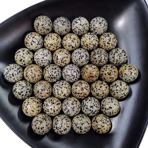 Polished Dalmatian jasper crystal spheres arranged in a black triangular display tray