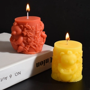 Detail of lit bear relief candles on books featuring intricate honeycomb carving