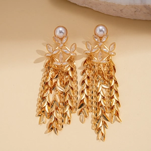Detail of 18K gold-plated floral earrings with white pearl and hanging leaf tassels