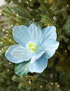 Light blue velvet artificial magnolia with silver glitter on a glowing Christmas tree