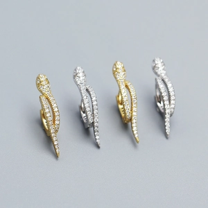 Close-up of gold and silver snake earrings set with sparkling micro-pave zircons