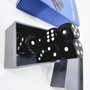 Close-up of Miracle Dice magic set with five black dice and grey plastic box detail