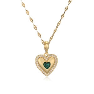 Gold heart pendant necklace with green center stone and crystals on white background