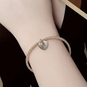 Minimalist S925 sterling silver mesh bracelet with heart pendant on model wrist