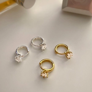 Detail of 925 sterling silver hoop earrings with round zircon stones in gold and silver