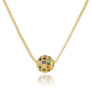 Macro shot of a golden box chain with a round pendant inlaid with colorful zircon stones