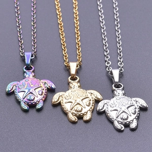 Detailed macro view of turtle pendants in gold, silver and rainbow finishes with starfish texture