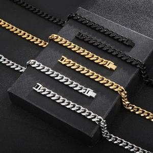 Detailed close-up of Cuban link necklaces and bracelets in gold, silver and black steel