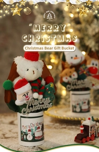Close-up of a Christmas plush bear bouquet with a Santa snowman bucket and festive decor