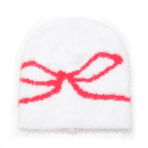Macro detail of the plush white knitted beanie fabric and pink bow jacquard pattern
