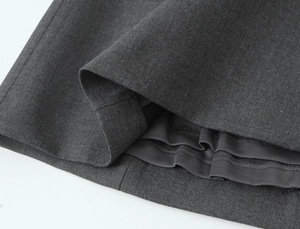 Gros plan sur l'ourlet en tissu gris foncé et la doublure lisse de la robe courte