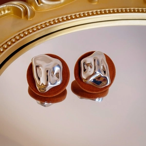 Detail of silver irregular metal inlay on brown suede resin earrings with reflections