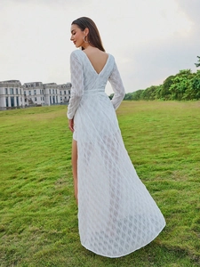 Elegant white long sleeve evening dress with V-back design and high-low flowing trail