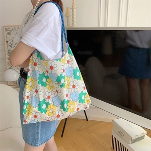 Detailed close-up of colorful floral print tote bag with woven Sozakka brand label