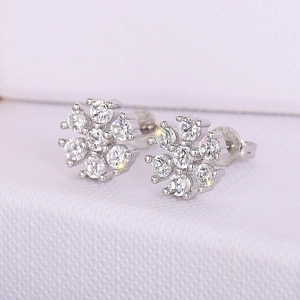 Macro view of crystal flower stud earrings featuring silver metal base and bright stones