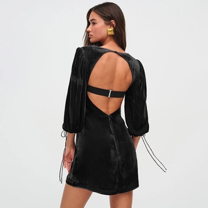Detail view of the open back cutout and lace-up cuffs on a black velvet mini dress