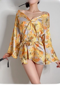 Detail eines gelben Satin-Kimonos mit Blumenmuster, weiten Ärmeln und einem Taillenband