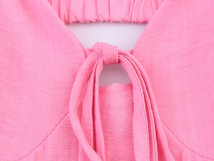 Close-up of pink textured summer dress featuring front cutout and tie-up knot detail